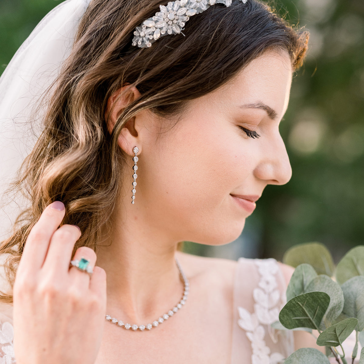 Bride smiles as wearing diamond earrings and necklace