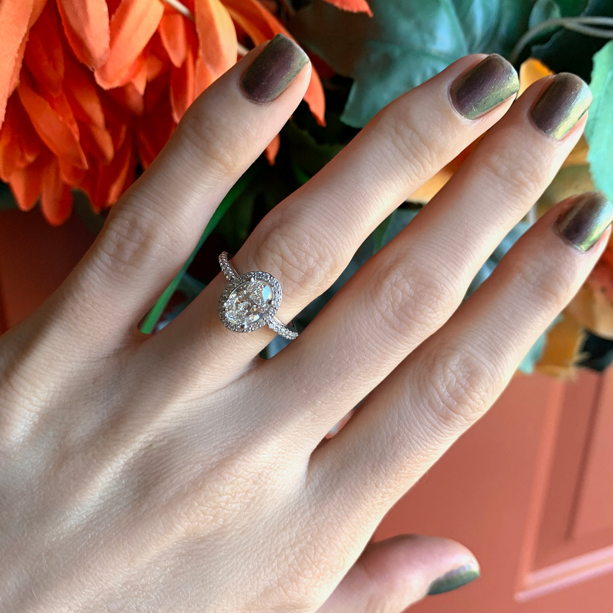 Halo engagement ring on hand with oval diamond