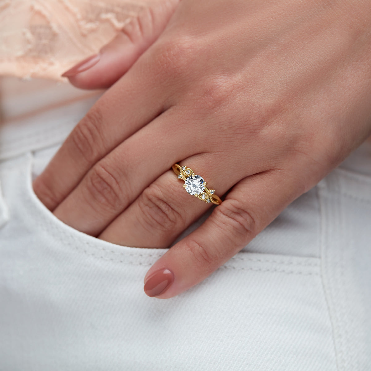 Floral inspired engagement ring in yellow gold on woman&#39;s hand