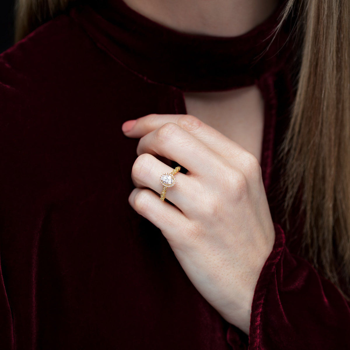 Vintage halo engagement ring in yellow gold on hand