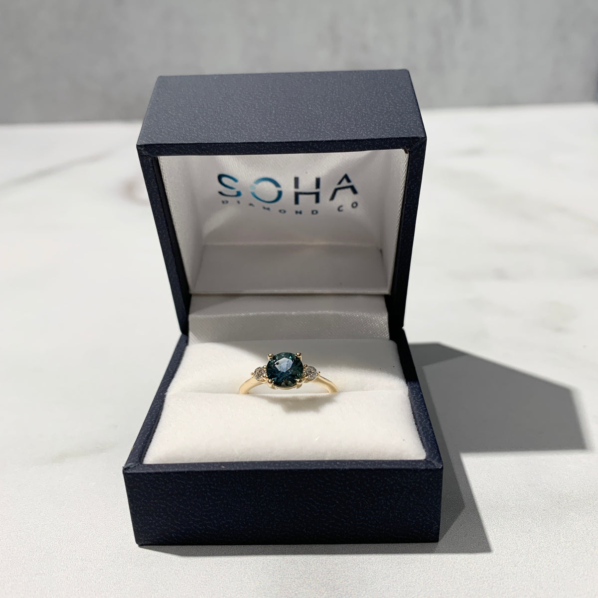 Teal sapphire center three stone ring