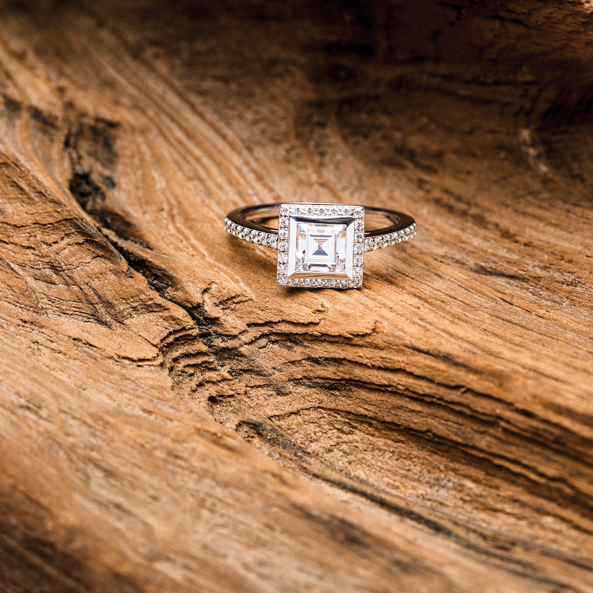 Square cut bezel set halo engagement ring